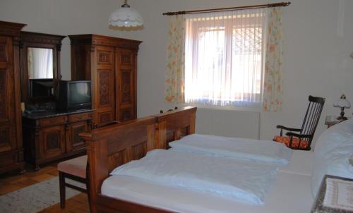 a bedroom with a bed and a tv and a bed sidx sidx sidx at Frühstückspension Kirchenwirt in Obervellach