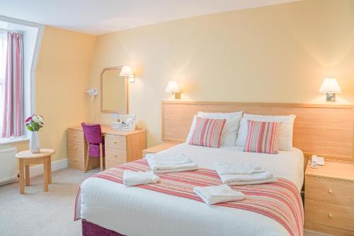 a bedroom with a bed with towels on it at New Beach Hotel in Great Yarmouth