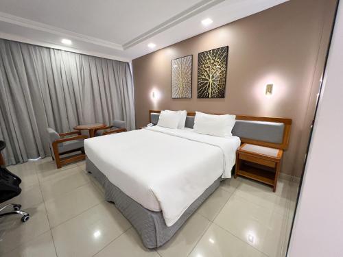 1 dormitorio con 1 cama blanca grande en una habitación en Castro's Park Hotel en Goiânia