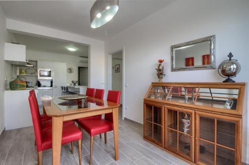 a kitchen and dining room with a table and red chairs at Enjoy Leuca Mare in Castrignano del Capo
