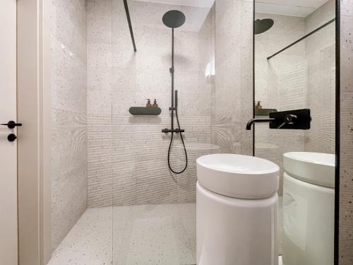 a white bathroom with a shower and a toilet at Apartament z widokiem na Rzeszów in Rzeszów