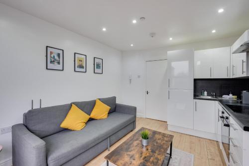 a living room with a gray couch and a table at Relax in a modern Cardiff home by the City Centre & Bute Park in Cardiff