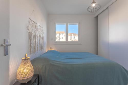 Un dormitorio blanco con una cama azul y una ventana en Appt centre ville 2 min de la gare, en Saint-Raphaël