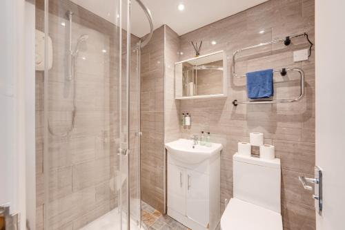 a bathroom with a shower and a toilet and a sink at Relax in a modern Cardiff home by the City Centre & Bute Park in Cardiff