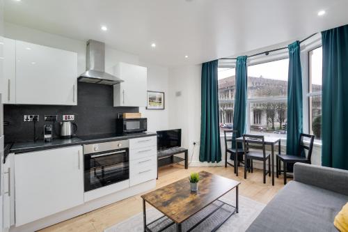 a kitchen and living room with a couch and a table at Relax in a modern Cardiff home by the City Centre & Bute Park in Cardiff