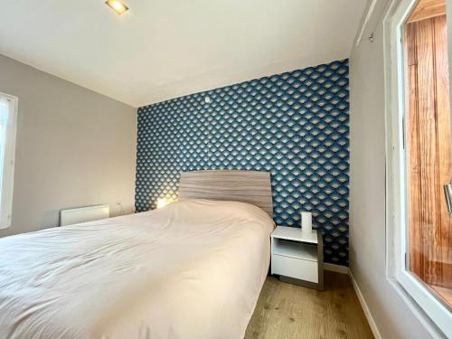1 dormitorio con cama y pared de color azul en COC - Côte et Mer, en Wissant