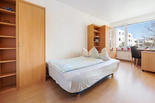 um quarto com uma cama, uma secretária e uma janela em Appartement Björn Schuhknecht em Hanôver