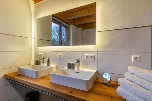 a bathroom with two sinks and a mirror at Vorderbühlhof in Oppenau