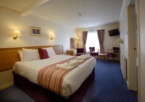 una habitación de hotel con una cama grande en una habitación en Croit Anna Hotel, en Fort William