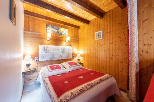 1 dormitorio con 1 cama en una habitación de madera en Studio Sabot de Vénus, en Thônes