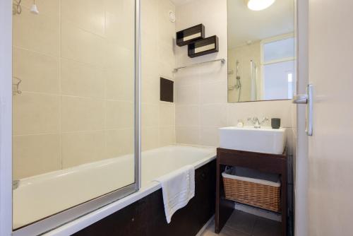y baño con bañera, lavamanos y ducha. en The Bermondsey Apartment en Londres