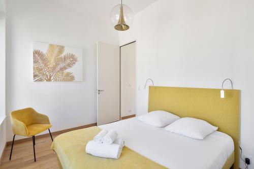 une chambre avec un lit et une chaise dans l'établissement Le Terre Neuve - Grande plage du sillon, à Saint-Malo