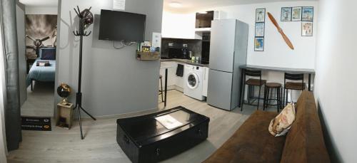 a room with a kitchen and a living room at La Suite du Pilote in La Ferté-Alais