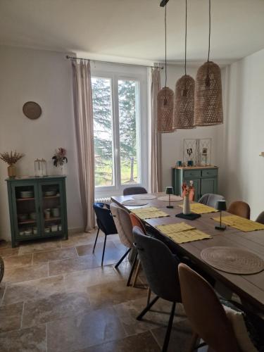 comedor con mesa, sillas y ventana en Grand Gîte Atypique au cœur du Pays des Châteaux, en La Chaussée-Saint-Victor