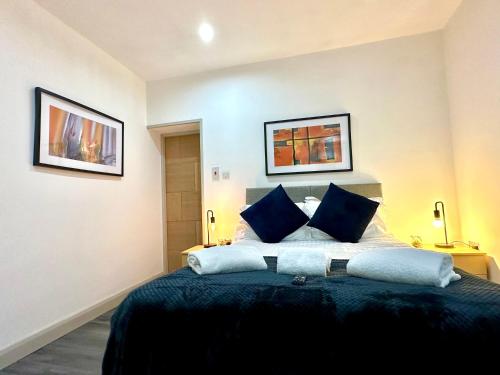 a bedroom with a large bed with blue pillows at York Street Apartments by Blackpool Service Apartments in Blackpool