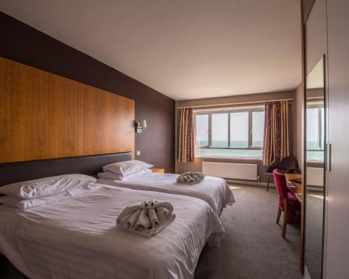 Shanklin Hotel في شانكلين: غرفه فندقيه سريرين عليها مناشف