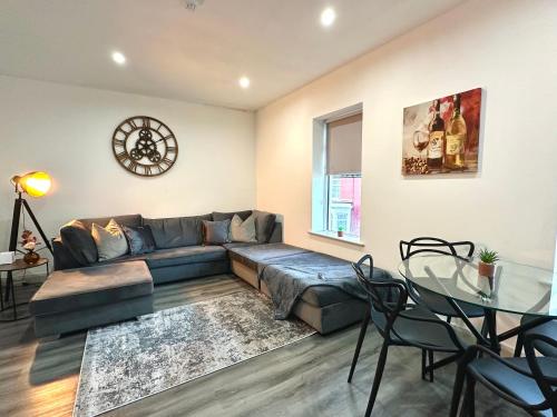 a living room with a couch and a glass table at York Street Apartments by Blackpool Service Apartments in Blackpool