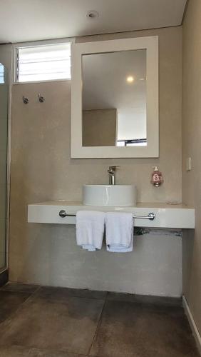 a bathroom with a sink and a mirror and towels at La Belle San Isidro Lofts - Loft Violetas in San Isidro