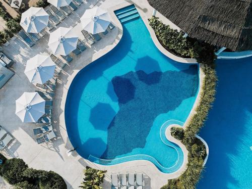 an overhead view of a swimming pool with blue water at Prinsotel La Dorada - 4* Sup in Playa de Muro