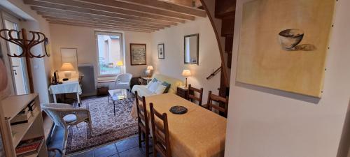 un salon avec une table et des chaises et un salon dans l'établissement Le Mans - Saint Blaise, au Mans