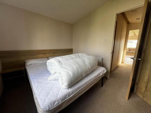 sypialnia z łóżkiem z białą pościelą w obiekcie Lovely 6 Berth Caravan At Cherry Tree Holiday Park, Ref 70403c w mieście Great Yarmouth