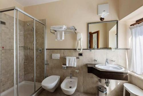 La salle de bains est pourvue de toilettes, d'un lavabo et d'une douche. dans l'établissement Miramonti Corvara Camera Familiare con bagno, à Corvara in Badia