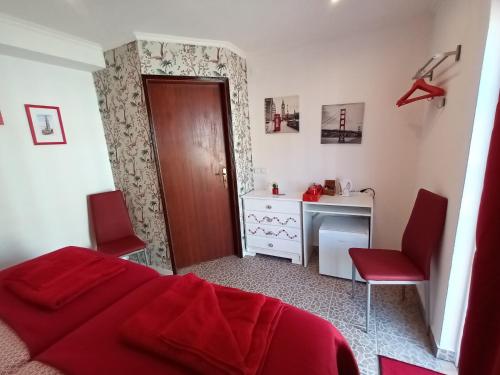 a bedroom with a red bed and a desk at B&B Quinta da Romãzeira in São Bartolomeu de Messines