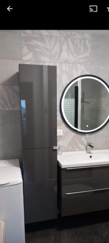 une salle de bain avec un miroir et un lavabo dans l'établissement Bel appartement 75m2, à La Rochelle