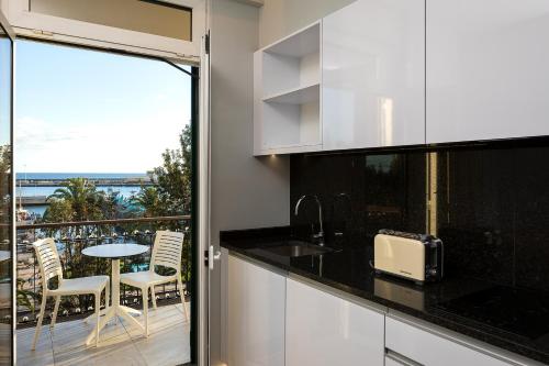 a kitchen with a balcony with a table and chairs at King David Suites by Homie in Funchal