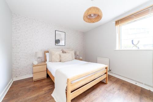 a bedroom with a bed and a brick wall at The Whitecross Street Apartment in London