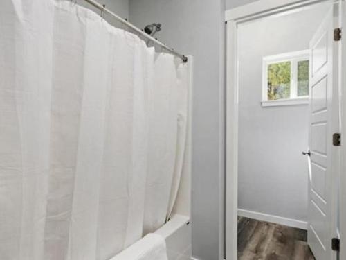 a white bathroom with a shower with a shower curtain at *5739* Escape to the Coffey Villas in Garden City