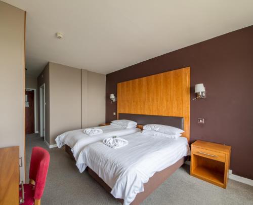 um quarto com 2 camas e lençóis brancos em Shanklin Hotel em Shanklin