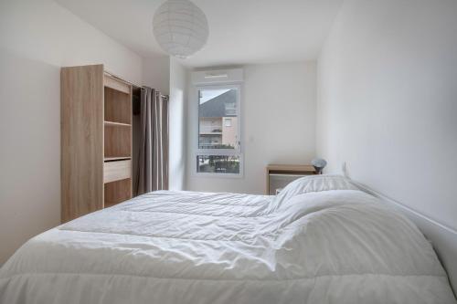 un lit blanc dans une chambre blanche avec une fenêtre dans l'établissement Virée au Pouliguen à 150m du port, au Pouliguen