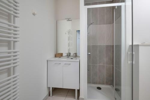 une salle de bain blanche avec une douche et un lavabo dans l'établissement Virée au Pouliguen à 150m du port, au Pouliguen