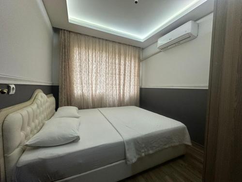 een slaapkamer met een wit bed en een raam bij DİAMOND PALACE APART HOTEL in Hatay