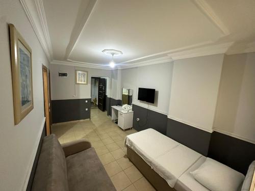 ein Wohnzimmer mit einem Sofa und einem TV in der Unterkunft DİAMOND PALACE APART HOTEL in Hatay