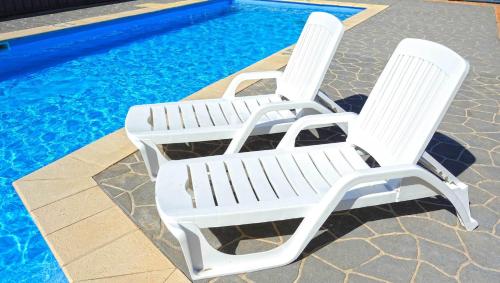 a white chair sitting in front of a pool of water at Abrolhos Reef Lodge in Geraldton