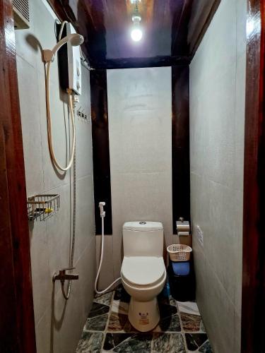 a small bathroom with a toilet and a shower at El Lobo Hostel in General Luna
