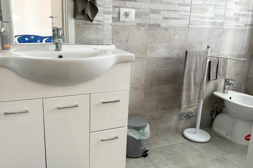 a white bathroom with a sink and a toilet at I TREPPONTI in Comacchio