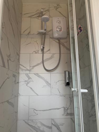 a shower with a shower head in a bathroom at Preto in Croydon