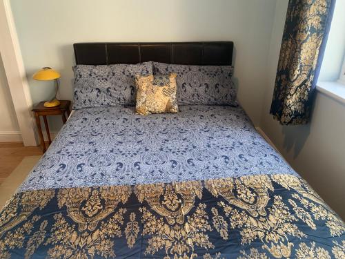 a blue and gold bed with a blue and gold bedspread at Preto in Croydon