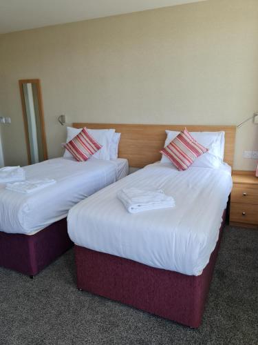 two beds sitting next to each other in a hotel room at Metropole Hotel in Torquay