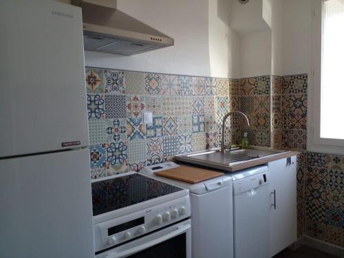 une cuisine avec un évier et une cuisinière dans l'établissement Studio 33 m2 , climatisé, parking extérieur privé gratuit, à Amélie-les-Bains-Palalda