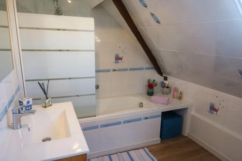 une salle de bain avec un lavabo et une baignoire dans l'établissement Maison de campagne avec piscine, jardin, à Bonneville-la-Louvet