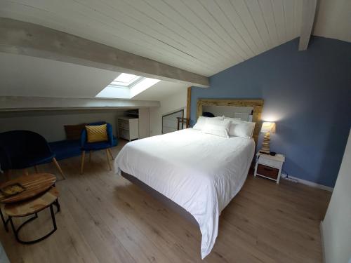 um quarto com uma grande cama branca e uma parede azul em Ty'Château Carignan de Bordeaux B&B em Carignan