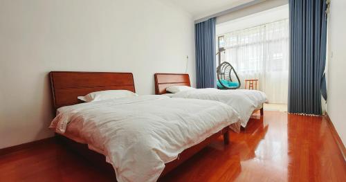 Duas camas num quarto com uma grande janela. em 凤凰古城宝庆民宿 em Fenghuang