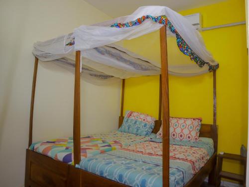 a bedroom with a bed with a canopy at La Case a Mamy in Nianing
