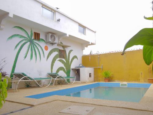 a house with a swimming pool in front of it at La Case a Mamy in Nianing