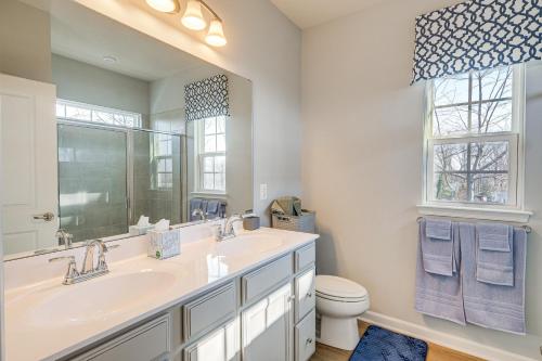 a bathroom with a sink and a mirror and a toilet at Charming Dale City Townhome Less Than 7 Mi to State Park! in Dale City