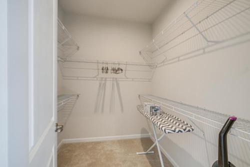 a walk in closet with white walls and white shelves at 30 Mi to Downtown DC Charming Dale City Townhome! in Dale City